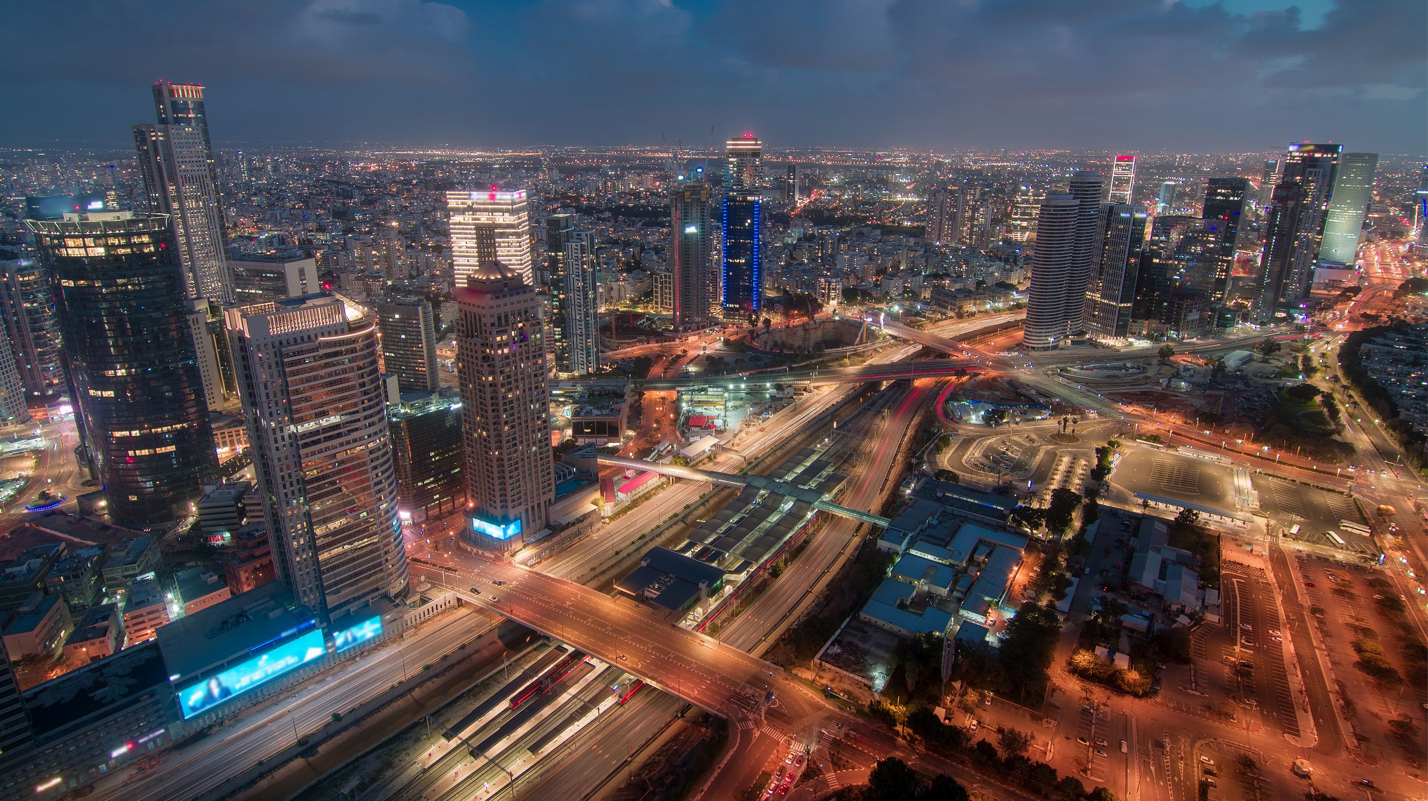 Night skyview of a city with cars driving buy on a freeway.