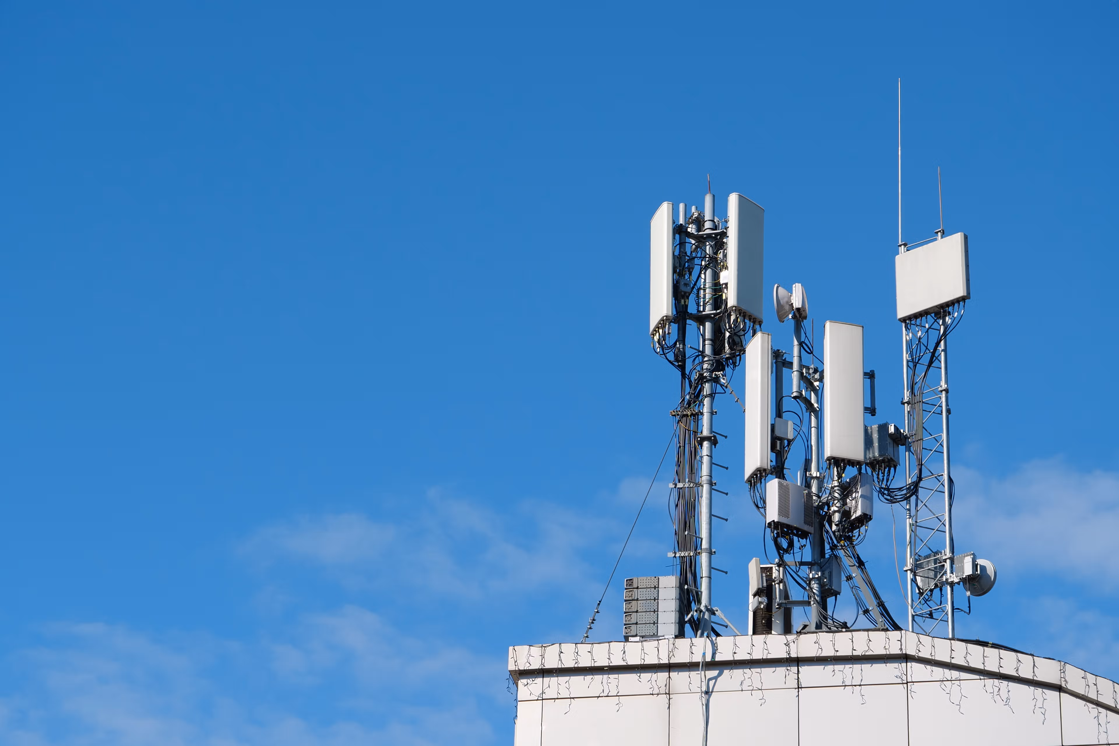 A group of cellular tower antennas on top of a building